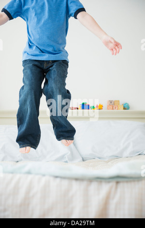 Geringen Teil der junge (4-5) springen auf Bett Stockfoto