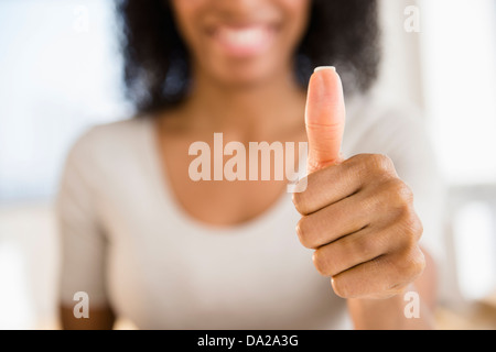 Frau macht Daumen hoch Geste Stockfoto