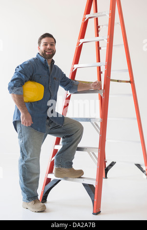 Porträt von Bauarbeiter mit Leiter stehend Stockfoto