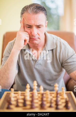 Porträt des Mannes konzentriert sich beim Schachspiel Stockfoto