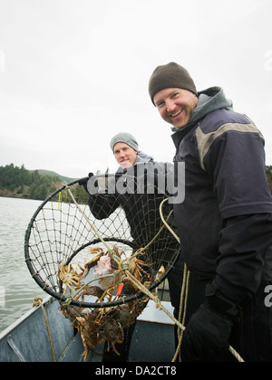 USA, Oregon, Rockaway Beach, Männer mit Krabben in Netz Stockfoto