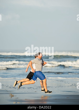 USA, Oregon, Rockaway Beach, Männer laufen am Strand Stockfoto