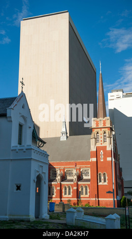 Ein modernes Bürogebäude steht im Gegensatz zu den alten roten Ziegeln einer Kirche auf Georges Terrace im CBD von Perth, Westaustralien Stockfoto