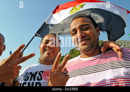 Zwei Männer zeigen die Victory-Zeichen auf dem Weg zu einer Demonstration gegen den ägyptischen Präsidenten Mursi am Tahrir-Platz in Kairo, Ägypten, 30. Juni 2013. Der ägyptische Präsident Mursi feiert ein Jahr im Amt am 30. Juni 2013 inmitten von Demonstrationen gegen seine islamistischen Regierung. Foto: MATTHIAS TOEDT Stockfoto