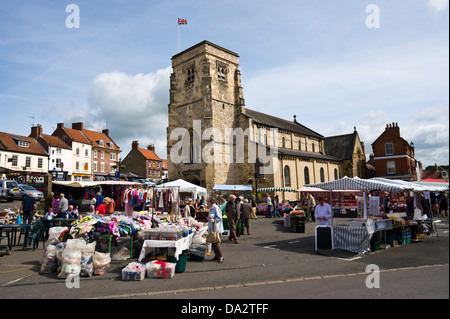 Im freien Wochenmarkt verkauft eine Vielzahl von waren neben der Kirche in Malton Ryedale North Yorkshire England UK Stockfoto