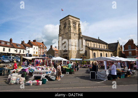 Im freien Wochenmarkt verkauft eine Vielzahl von waren neben der Kirche Ryedale in Malton North Yorkshire England UK Stockfoto