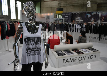 Drei Besucher sitzen direkt hinter einem Mannequin während der Fashion fair "& Brot" auf dem ehemaligen Flughafen Tempelhof in Berlin, Deutschland, 2. Juli 2013. Die Präsentationen der Kollektionen für Frühjahr/Sommer 2014 statt vom 02 bis 4. Juli 2013. Foto: Marc Tirl/dpa Stockfoto