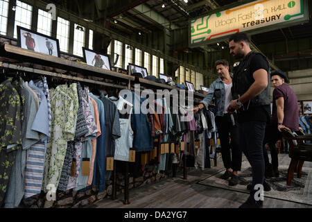 Drei Männer sprechen während der Fashion fair "& Brot" auf dem ehemaligen Flughafen Tempelhof in Berlin, Deutschland, 2. Juli 2013. Die Präsentationen der Kollektionen für Frühjahr/Sommer 2014 statt vom 02 bis 4. Juli 2013. Foto: Marc Tirl/Dpa / / Alamy Live News Stockfoto