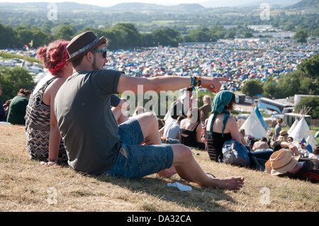 Ein paar sitzen an der Spitze des Parks am Glastonbury Festival des zeitgenössischen Performing Arts 2013, genießen Sie den Blick. Stockfoto