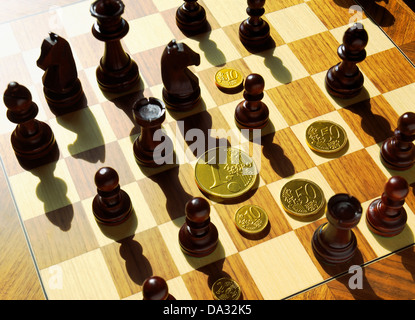 Schachfiguren und Euro-Goldmünzen auf Schachbrett Stockfoto