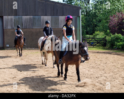 Junge Mädchen lernen, Reiten im Stall, UK 2013 Stockfoto