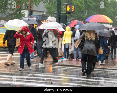 Fußgänger im Regen unter Bordüren, New York City Stockfoto