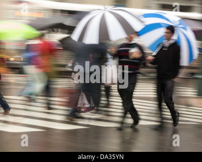 Fußgänger im Regen unter Bordüren, New York City Stockfoto