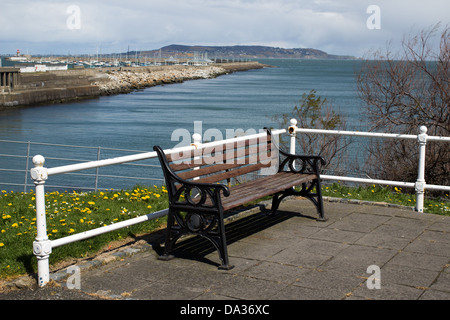 Eine Bank, mit der Promenade in Dun Laoghaire im Hintergrund, Irland. Stockfoto