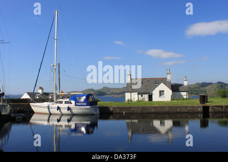 Yacht und Kanalseite Gebäude mit Reflexionen in Crinan Kanal am westlichen Ende des Kanals, Argyll and Bute, Scotland. Stockfoto