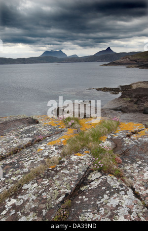 Felsen in Sparsamkeit abgedeckt und Flechten unter einem dramatischen Himmel auf der Küstenlinie von enard Bay, Sutherland, North West, Schottland, Großbritannien Stockfoto