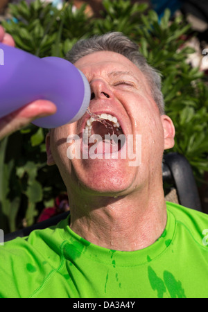 Sportler trinken aus der Flasche Wasser Stockfoto