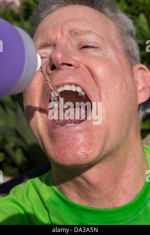 Sportler trinken aus der Flasche Wasser Stockfoto