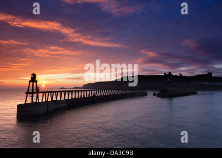 Sonnenaufgang über der Mündung des Flusses Esk, Pier Ost und der Hafeneinfahrt von Whitby. Stockfoto