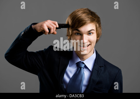 Verrückte Geschäftsmann geben einen Schuss auf seinen eigenen Kopf Stockfoto