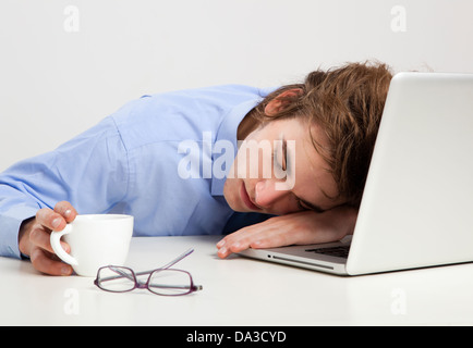 Erschöpften Geschäftsmann im Büro schlafen über den laptop Stockfoto