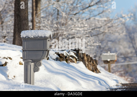 Postfächer auf einer Vorstadt Landstraße in frisch gefallenen Schnee bedeckt. Stockfoto