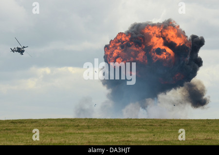 Ein AH-64D Apache der britischen Armee führt einen Demo-Angriff mit Pyrotechnik für Waffenexplosionen durch Stockfoto