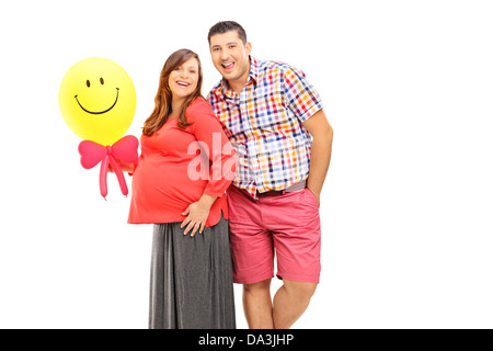 Glückliches Paar erwarten ein Baby und hält einen Ballon isoliert auf weißem Hintergrund Stockfoto