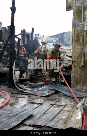 Ein Feuerwehrmann, ein Maschinist in einer eingestürzten Baustelle ziehen Stockfoto