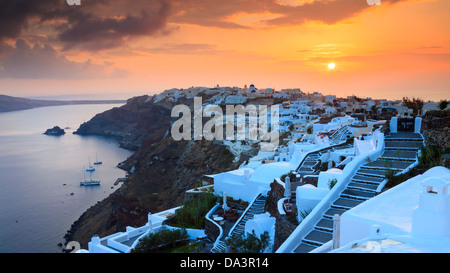 Die Sonneneinstellungen über das schöne Dorf Oia auf der Insel Santorin in Griechenland. Stockfoto