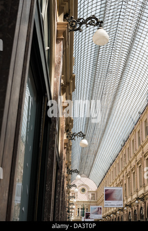 BRÜSSEL, Belgien — das elegante Glaskuppeldach der Galeries Royales Saint-Hubert beleuchtet die historische Einkaufspassage in Brüssels Unterstadt. Diese 1847 eröffnete europäische überdachte Einkaufsstraße umfasst drei miteinander verbundene Galerien mit Luxusläden und Cafés. Stockfoto