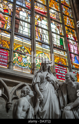 BRÜSSEL, Belgien — Marienstatuen vor einem bunten Buntglasfenster in der Kathedrale St. Michael und St. Gudula (auf Französisch Co-Cathédrale collégiale des SS-Michel et Gudule). An diesem Ort wurde im 11. Jahrhundert eine Kirche gegründet, der heutige Bau stammt jedoch aus dem 13. Bis 15. Jahrhundert. Die römisch-katholische Kathedrale ist der Veranstaltungsort vieler staatlicher Veranstaltungen wie Krönungen, königliche Hochzeiten und Staatsbeerdigungen. Sie hat zwei Schutzheilige, St. Michael und St. Gudula, die beide auch Schutzheilige von Brüssel sind. Stockfoto