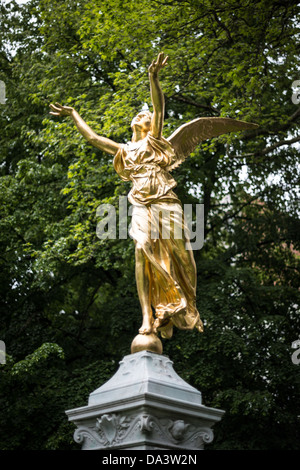 BRÜSSEL, Belgien — Eine vergoldete Engelsstatue steht auf dem Square de Meeûs, im Europäischen Viertel von Brüssel. Das Denkmal befindet sich auf dem landschaftlich gestalteten Platz in der Nähe des Komplexes des Europäischen Parlaments. Der Square de Meeûs dient als Grünfläche und künstlerischer Mittelpunkt im administrativen Zentrum der Europäischen Union. Stockfoto