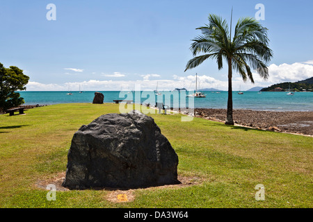 Einen Felsen oder Stein oder Felsbrocken steht allein, mit einer Palme auf der rechten Seite.  Airlie Beach, Australien. In der Nähe von Great Barrier Reef. Stockfoto