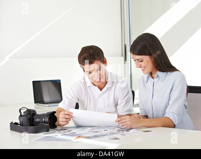 Bild-Schreibtisch in Bildagentur mit Bildern und Kamera auf ihrem Schreibtisch Stockfoto