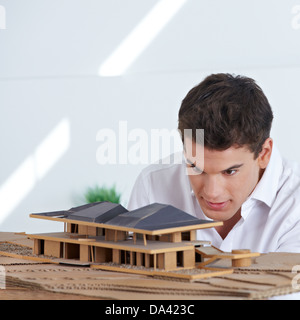 Architekt im Büro Blick auf Hausmodell aus Holz und Pappe Stockfoto