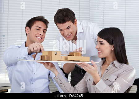 Drei Architekten in ihrem Büro ein Gebäudemodell diskutieren Stockfoto