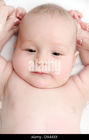 Schöne Baby auf Rücken und Mutters Hände Stockfoto