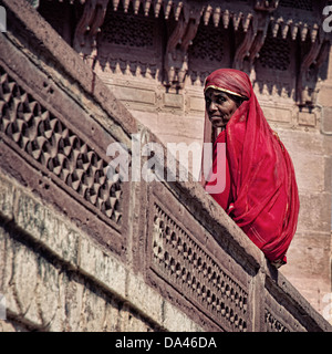 Frau trägt rote Sari sitzen im Mehrangarh Fort. Jodhpur, Rajasthan, Indien Stockfoto