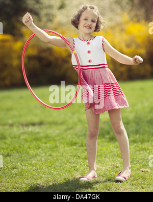 Junges Mädchen mit Hula-Hoop am Arm in einem park Stockfoto