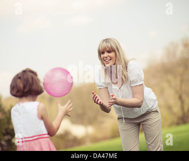 Familie wirft Ball zueinander im park Stockfoto