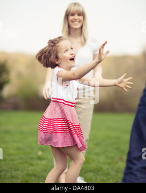 Vater Mutter und Tochter wirft Ball zueinander im park Stockfoto