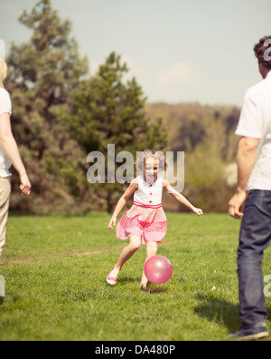 Tochter treten Ball zu Vater und Mutter im park Stockfoto