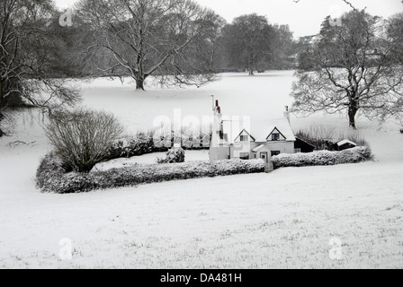 Blick auf isolierte Hütte mit abgesicherten Garten in Schnee bedeckt, Lee Common, Chiltern Hills, Buckinghamshire, England, Februar Stockfoto