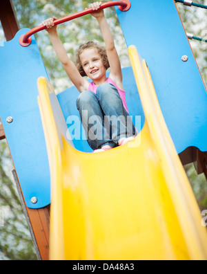 Junges Mädchen auf Folie auf Spielplatz Stockfoto