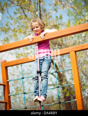 Junge Mädchen stehen an der Spitze des Seils und Klettergerüst Stockfoto