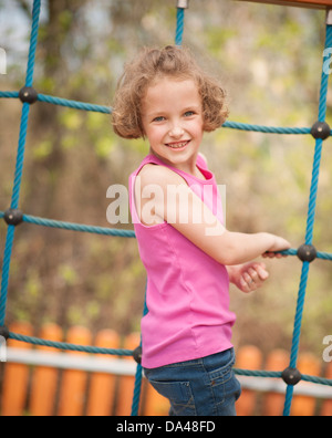 Junges Mädchen auf Klettern net Hinwendung zu Gesicht Kamera Stockfoto