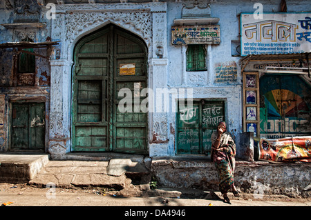 Frau sitzt vor einer schönen blau lackierten Front. Jodhpur, Rajasthan, Indien Stockfoto