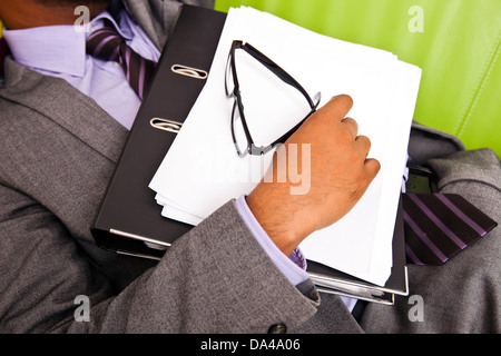 Nahaufnahme des Schlafens Unternehmenshilfe Hand hält Ordner Stockfoto