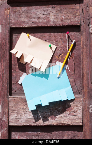 Anderes Papier für anzeigen und Bleistift auf einer alten Holztür mit Schatten aus Sonnenlicht Stockfoto
